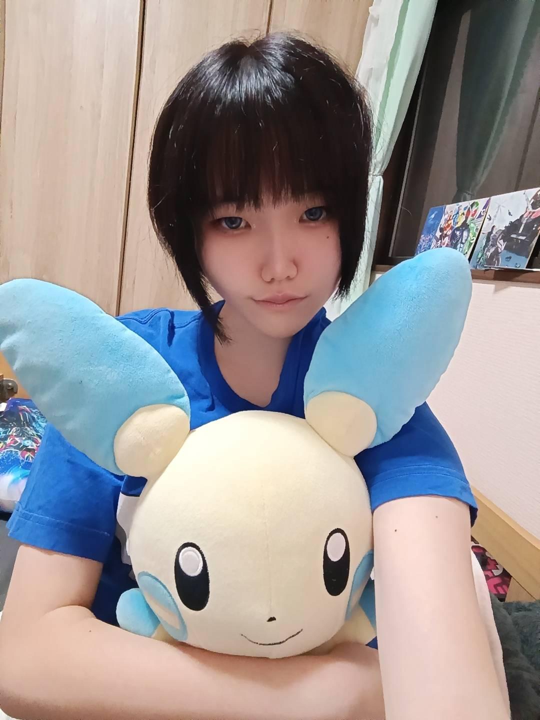 青いTシャツで大きな水色のぬいぐるみを抱えた鏡銀牙